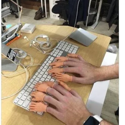 Mini hands at the end of each finger typing at a keyboard 