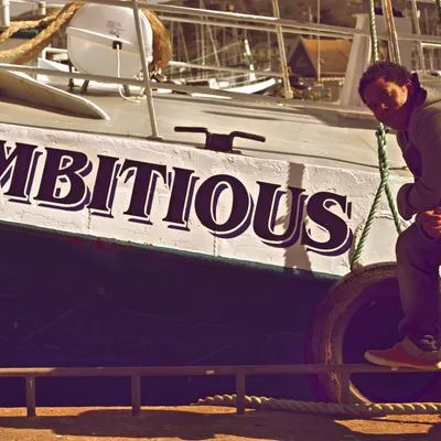 A boat with the word "Ambitious" painted on its' side. 