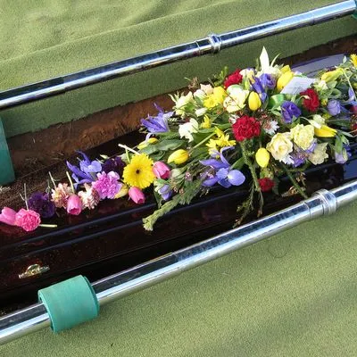 A casket being lowered into a grave. 
