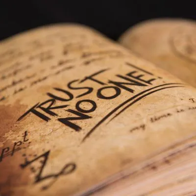 Book with the words "trust no one" written over the page