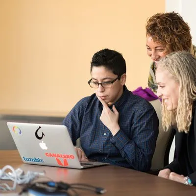 3 women looking at a laptop