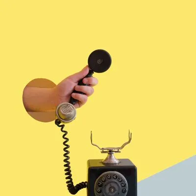 Someone holding the receiver of an old phone