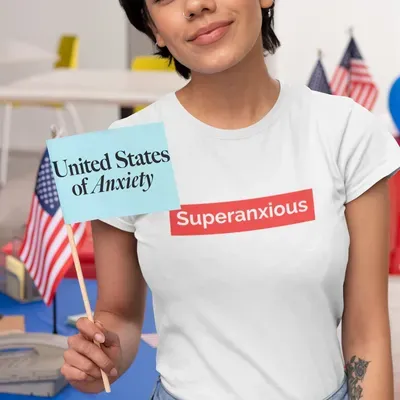 Lady holding a flag that says united states of anxiety 