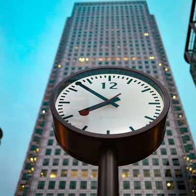 Large clock in front of high rise building 