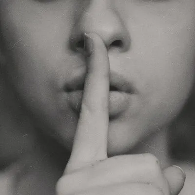 women holding her finger to her lips.