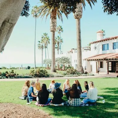 Group of women sat in a circle on grass