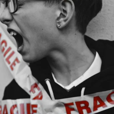 A person screaming while wrapped in tape reading "Fragile" 