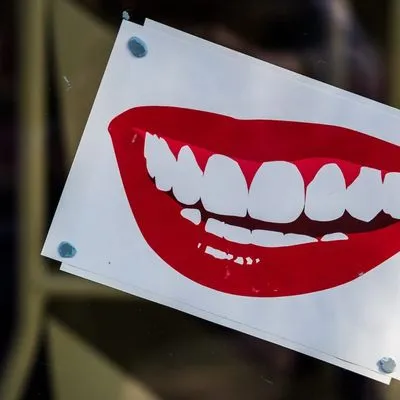 A pop art picture of a smile with bright red lipstick.