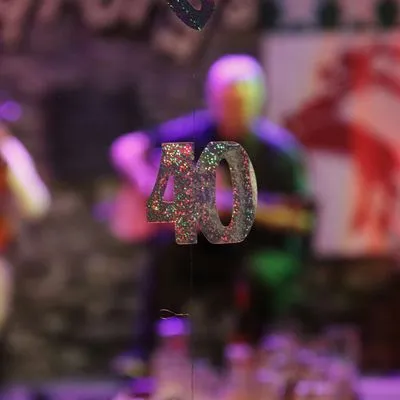 Glittery 40 on a blurry party background. Photo by Noah Gremmert on Unsplash