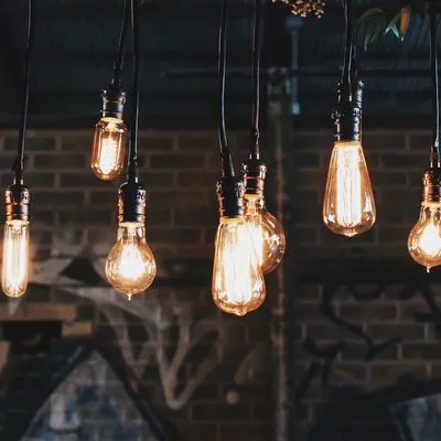 A row of old fashioned light bulbs glowing in the dark.